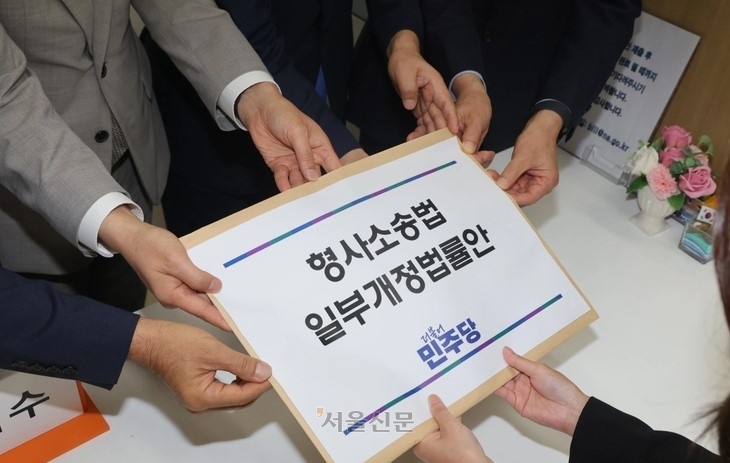 지난 9일 민주당 형사소송법 개정 태스크포스(TF) 소속 의원들이 국회 의안과에 보완수사권 폐지를 담은 형소법 개정안을 제출하는 모습. 안주영 전문기자