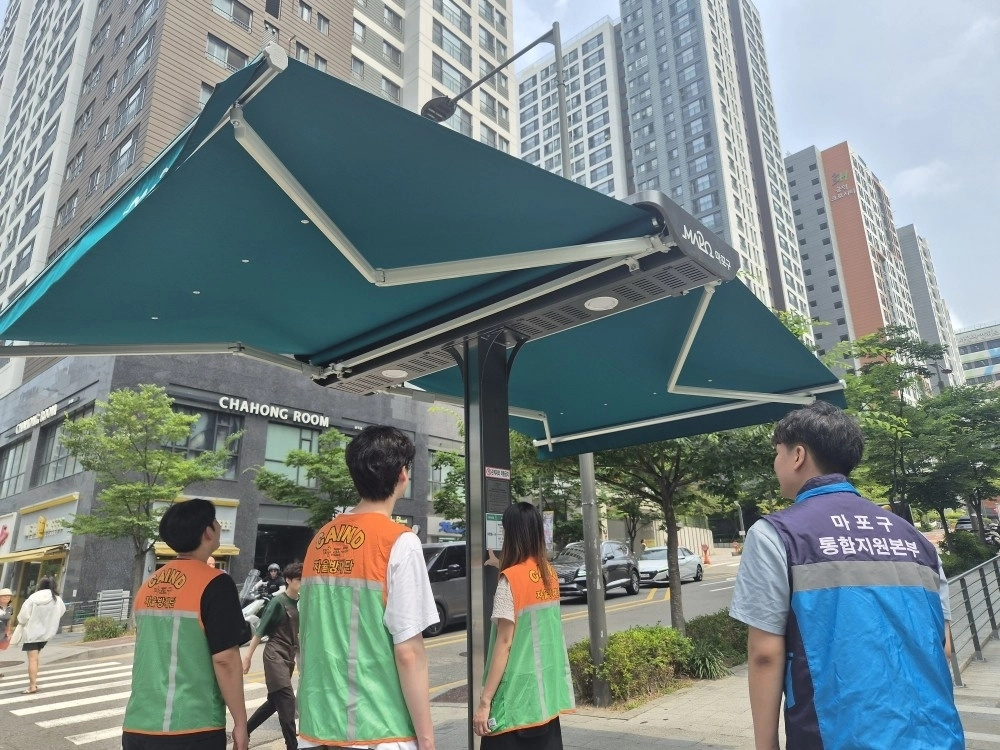 지난달 서울 마포구 공무원들과 자율방재단이 횡단보도 앞에 설치된 스마트그늘막을 점검하고 있다. 마포구 제공