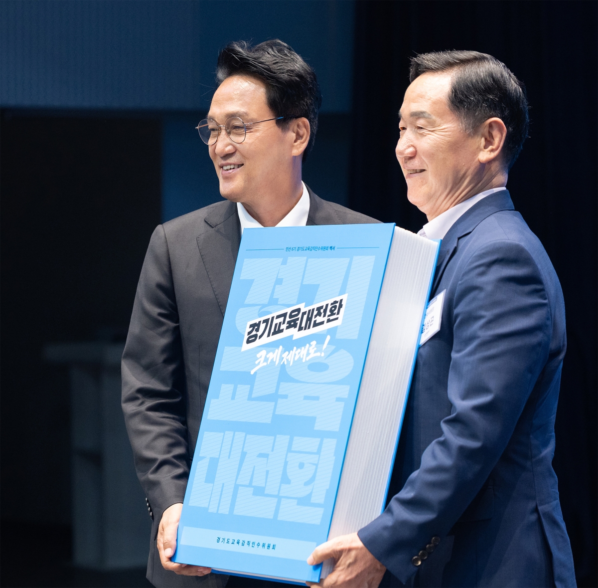 안민석 경기도교육감이 15일 민선 6기 안민석 경기도교육감직인수위원회 김상곤 위원장으로부터 인수위 활동 결과와 정책 제안을 담은 백서를 받고 있다. 경기도교육청 제공