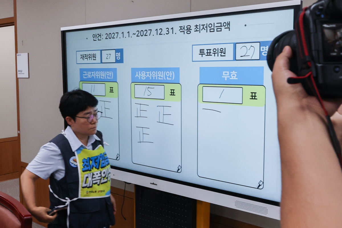 지난 14일 정부세종청사에서 열린 최저임금위원회 제14차 전원회의에서 내년도 최저임금이 시간당 1만700원으로 최종 결정된 뒤 근로자위원인 이미선 민주노총 부위원장이 회의장을 빠져 나가고 있다. 연합뉴스