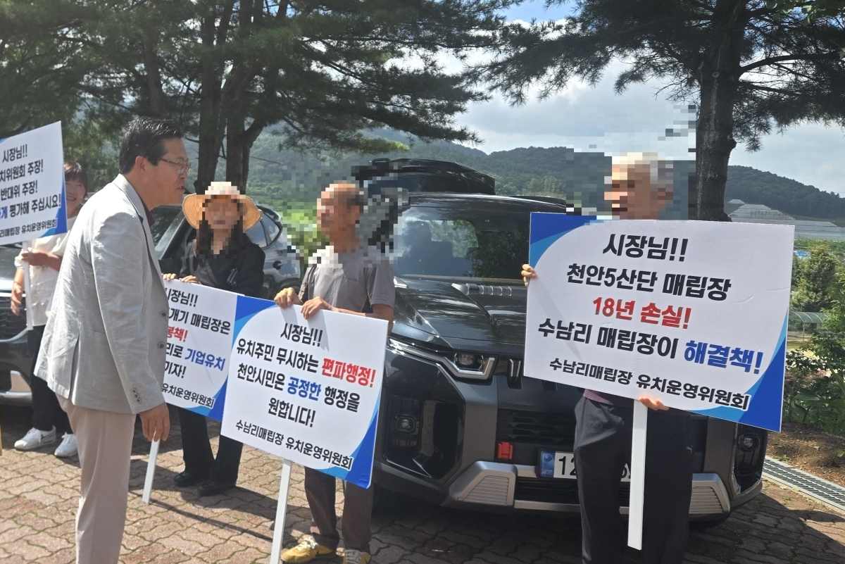 장기수 천안시장이 동면 폐기물 매립시설 유치를 주장하며 손팻말을 들고 ‘천안시 편파행정’에 항의하는 주민들과 인사를 나누고 있다. 독자 제공