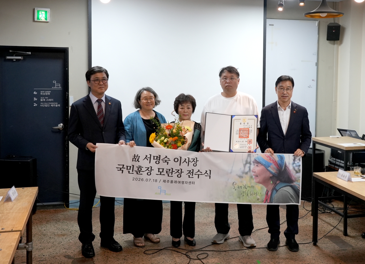 최휘영(왼쪽) 문화체육관광부 장관이 지난 18일 제주 서귀포 제주올레 여행자센터에서 서명숙 제주올레 이사장의 유가족에게 국민훈장 모란장을 전달한 뒤 기념촬영을 하고 있다. 전수식에는 장남 등 유가족과 위성곤(오른쪽) 제주지사, 안은주(왼쪽 두 번째) 제주올레 대표가 참석했다. 제주올레 제공