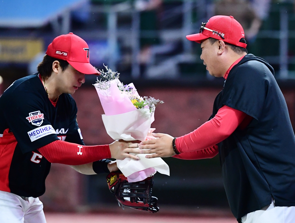 이범호 KIA 감독(오른쪽)이 19일 SSG전에서 통산 200승을 거둔 뒤 나성범으로부터 축하의 꽃다발을 받고 있다.     KIA 타이거즈 제공