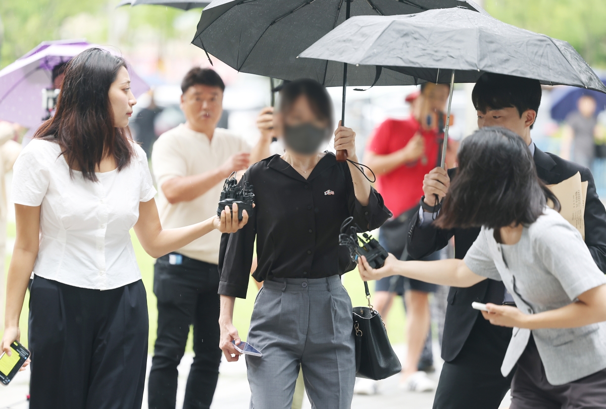 6·3 지방선거 개표소로 사용된 올림픽공원 핸드볼경기장 문 앞에서 체육단체 직원들의 장내 사무실 진입을 막아 업무 방해 혐의를 받는 30대 여성이 21일 구속 전 피의자 심문(영장실질심사)를 위해 서울 송파구 서울동부지방법원으로 출석하고 있다. 연합뉴스