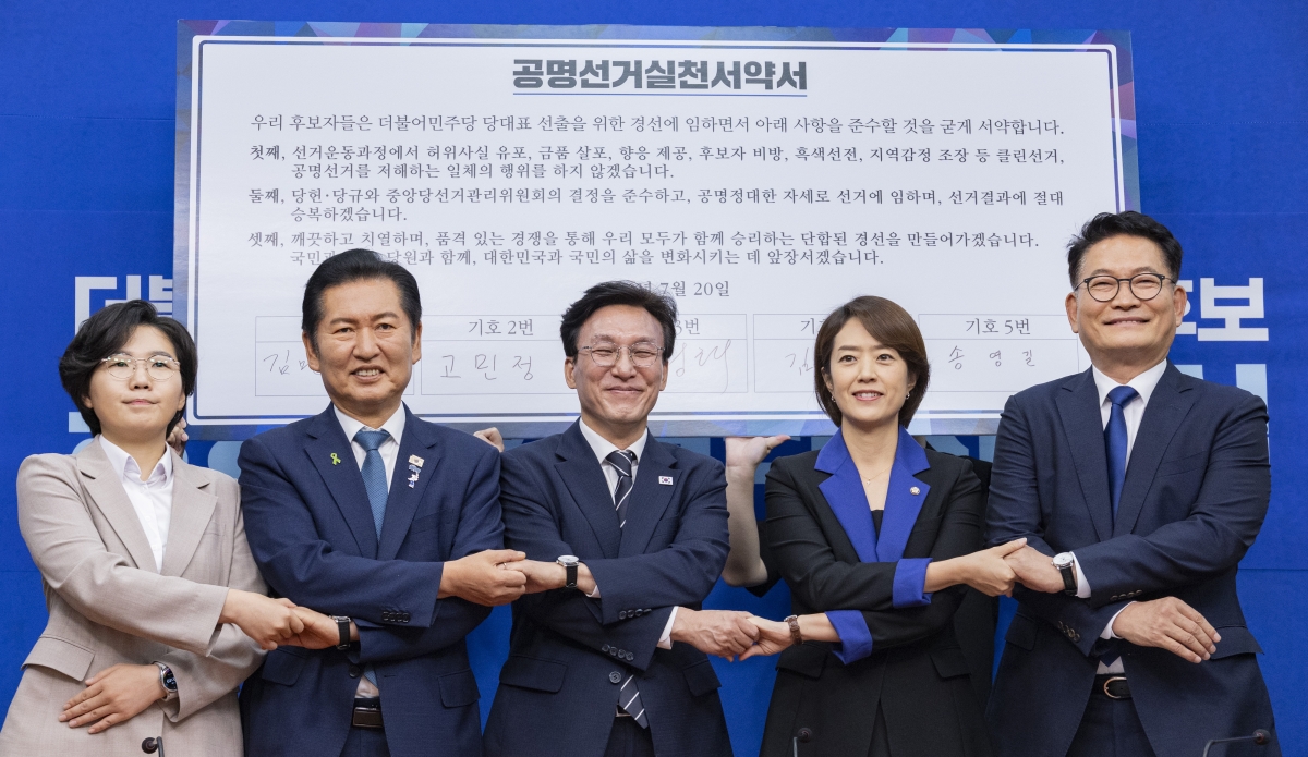 더불어민주당 8.17 전당대회에서 당 대표직에 출마하는 후보들이 20일 국회에서 열린 공명선거 실천 서약식에 참석해 문서에 서명한 뒤 손을 맞잡고 기념 촬영하고 있다. (왼쪽부터) 김보미, 정청래, 김민석, 고민정, 송영길 후보. 2026.7.20. 연합뉴스