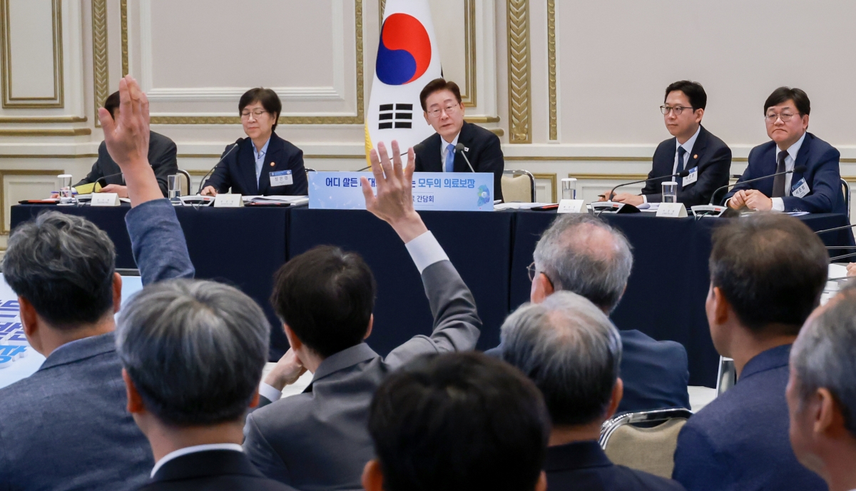 이재명 대통령이 22일 청와대 영빈관에서 주재한 ‘지역·필수·공공의료 간담회’에서 참석자들이 손을 들고 발언권을 요청하고 있다. 이 대통령 왼쪽과 오른쪽은 각각 정은경 보건복지부 장관, 배경훈 부총리 겸 과학기술정보통신부 장관. 연합뉴스