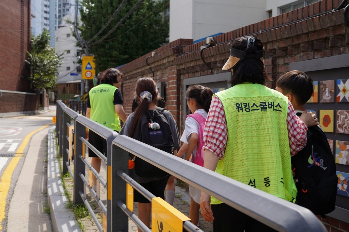 성동구 ‘워킹스쿨버스’의 교통안전지도사가 아이들과 함께 등하교길을 걷고 있다. 성동구 제공