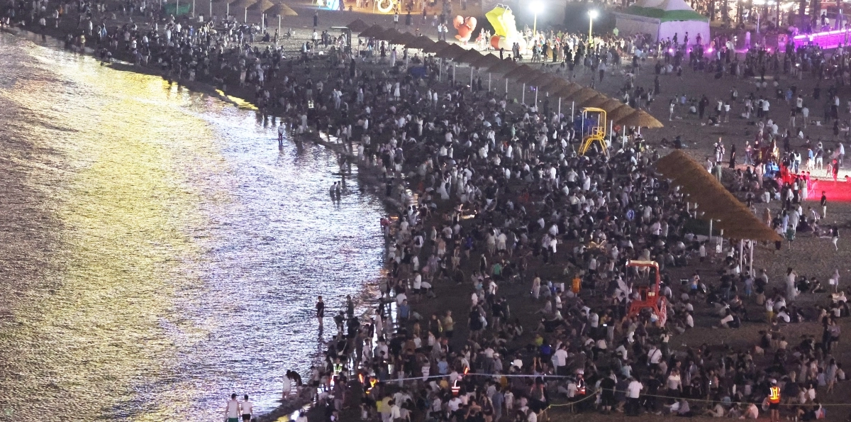 폭염특보와 열대야 현상이 이어진 25일 밤 부산 수영구 광안리해수욕장에서 시민과 관광객들이 바닷가를 찾아 중복 더위를 식히고 있다. 연합뉴스