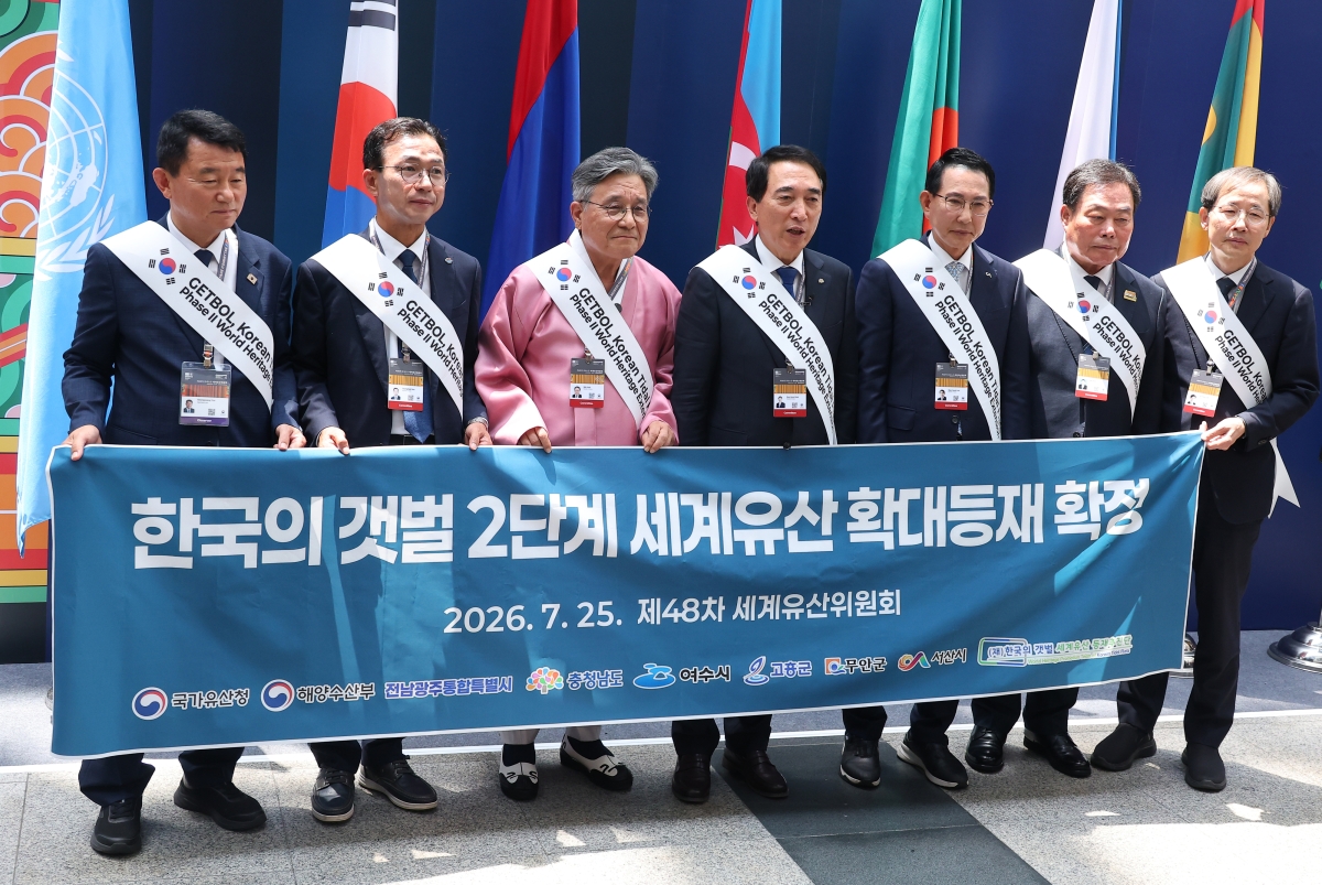 허민(왼쪽 세 번째) 국가유산청장과 박수현(왼쪽 네 번째) 충남도지사 등 지방자치단체장들이 25일 부산 벡스코에서 ‘한국의 갯벌’의 유네스코 세계유산 확대 등재를 축하하고 있다. 연합뉴스