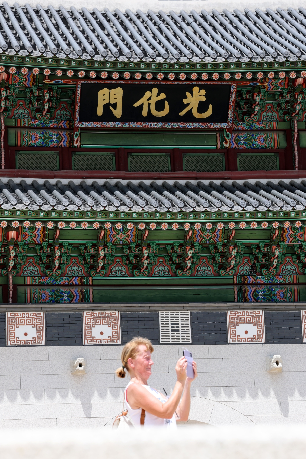 한 외국인 관광객이 26일 서울 종로구 광화문 앞에서 기념사진을 찍고 있다. ﻿ 뉴스1
