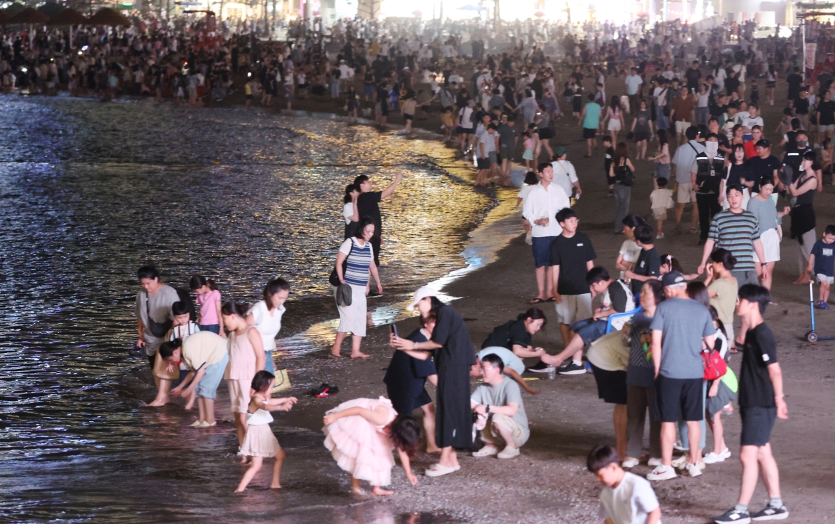 지난 25일 부산 수영구 광안리해수욕장이 드론쇼 관람객과 피서객들로 늦은 시간까지 붐비고 있다. 연합뉴스