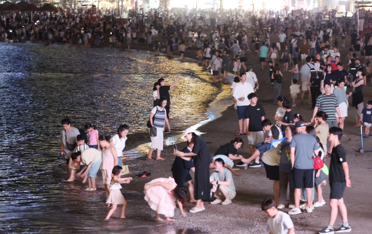 지난 25일 부산 수영구 광안리해수욕장이 드론쇼 관람객과 피서객들로 늦은 시간까지 붐비고 있다. 연합뉴스