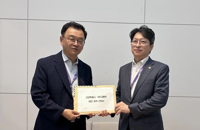 민경선 고양시장(왼쪽)이 29일 제주에서 열린 ‘2026 도심항공교통(UAM) 서비스 쇼케이스’에서 홍지선 국토교통부 제2차관에게 고양시 핵심 광역교통사업의 국가계획 반영과 정부 지원을 요청하며 건의서를 전달하고 있다.