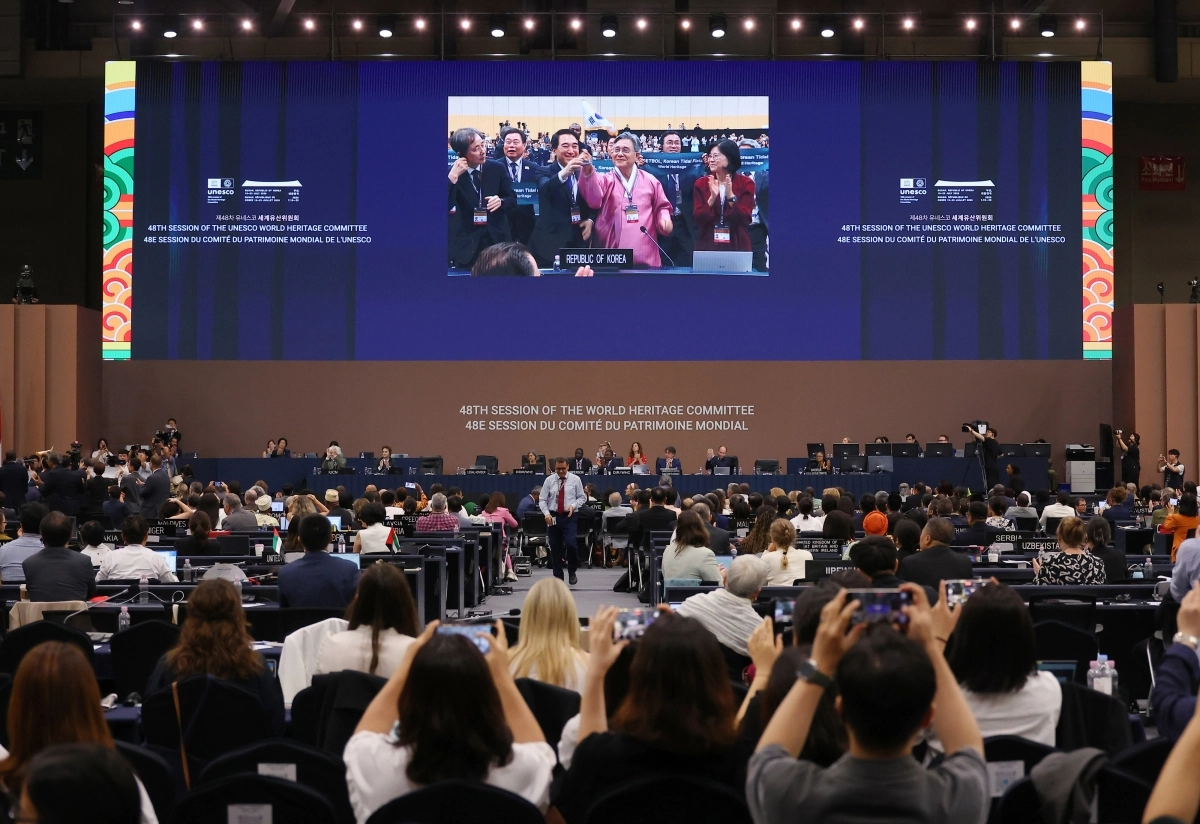 7월 25일 부산 해운대구 벡스코에서 열린 제48차 유네스코 세계유산위원회 본회의에서 ‘한국의 갯벌’(Getbol, Korean Tidal Flats) 2단계 등재가 확정되자 허민 국가유산청장과 박수현 충남도지사 등이 태극기를 흔들며 축하하고 있다.  뉴스1