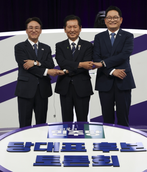 더불어민주당 8·17 전당대회에 출마한 김민석(왼쪽부터)·정청래·송영길 당대표 후보들이 29일 서울 마포구 MBC에서 열린 방송토론회에서 손을 맞잡고 기념 촬영하고 있다. 국회사진기자단