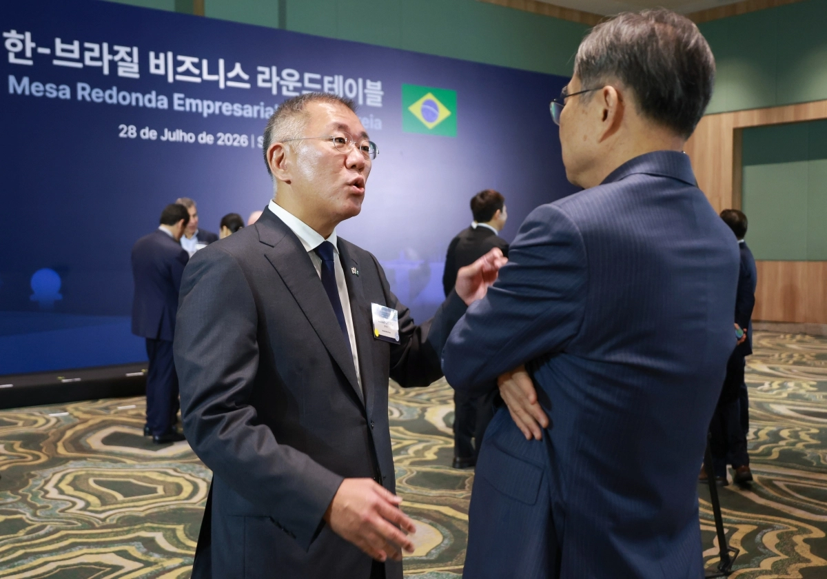 정의선(왼쪽) 현대자동차그룹 회장이 조현 외교부 장관과 28일(현지시간) 브라질 상파울루의 한 호텔에서 이재명 대통령이 참석한 가운데 열린 한·브라질 비즈니스 라운드테이블에서 대화하고 있다. 상파울루 연합뉴스