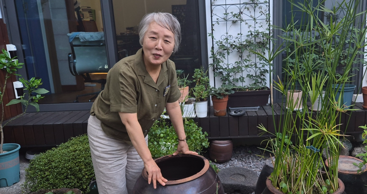 최근 에세이 ‘나이 60, 생판 남들과 산다’를 펴낸 조선희 전 제주문화예술재단 경영기획본부장이 29일 공유주택 미로헌 중정 마당에서 항아리를 만지다 미소짓고 있다. 제주 강동삼 기자