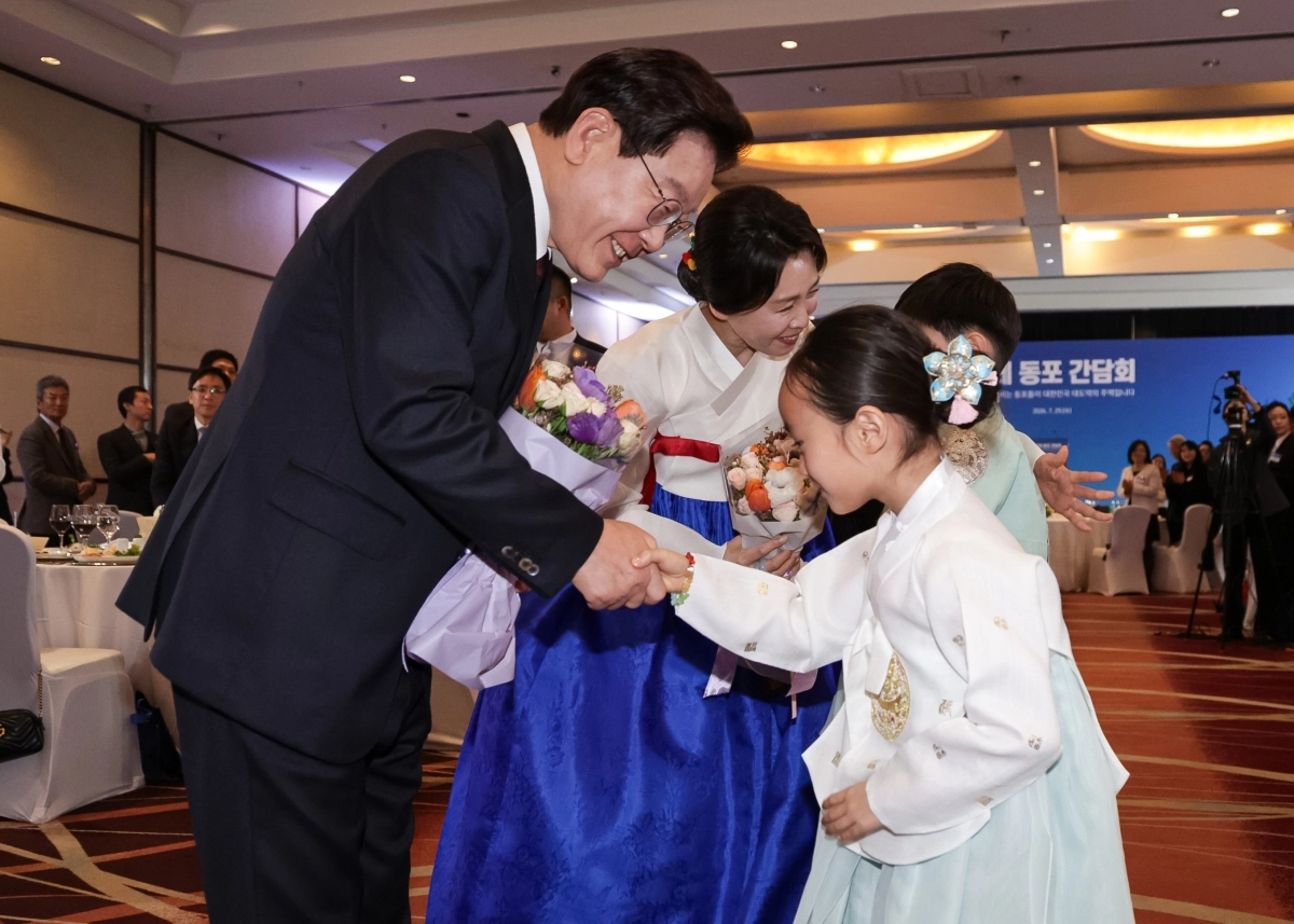 이재명 대통령과 김혜경 여사가 29일(현지시간) 칠레 산티아고의 한 호텔에서 열린 동포 만찬 간담회에서 어린이들에게 꽃다발을 전달받은 뒤 웃으며 인사를 나누고 있다. 산티아고 뉴스1