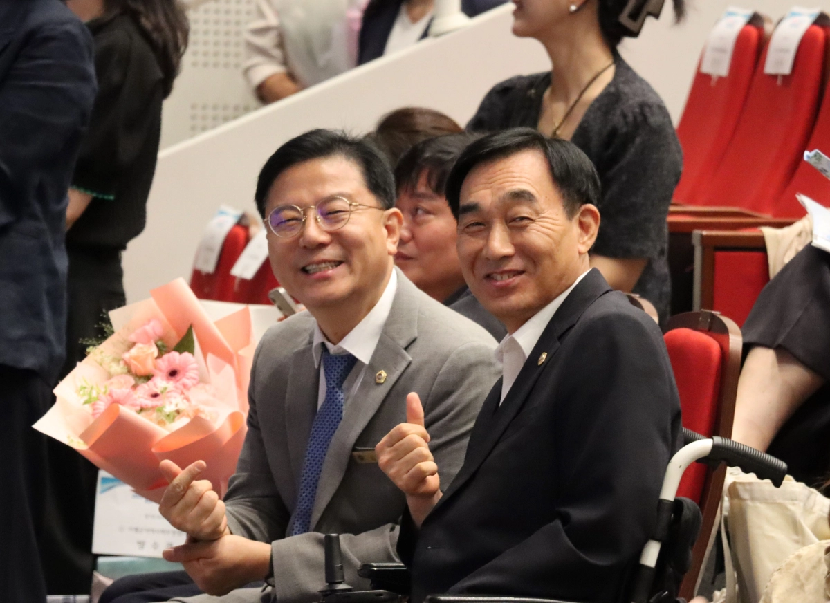 ▲‘2026년 제16회 경기도 지역사회보장협의체 지역대회’에서 김현덕 의원(오른쪽)이  행사에 참석한 보건복지위원회 김성기 의원과 함께 기념촬영을 하고 있다. (사진=경기도의회)