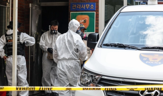 23일 오전 8시 29분께 경북 경산시 사동 한 아파트 관리실 안에서 폭발 추정 사고가 난 가운데 경찰 과학수사대가 증거물로 보이는 물건을 담은 종이상자를 가지고 철수하고 있다. 연합뉴스