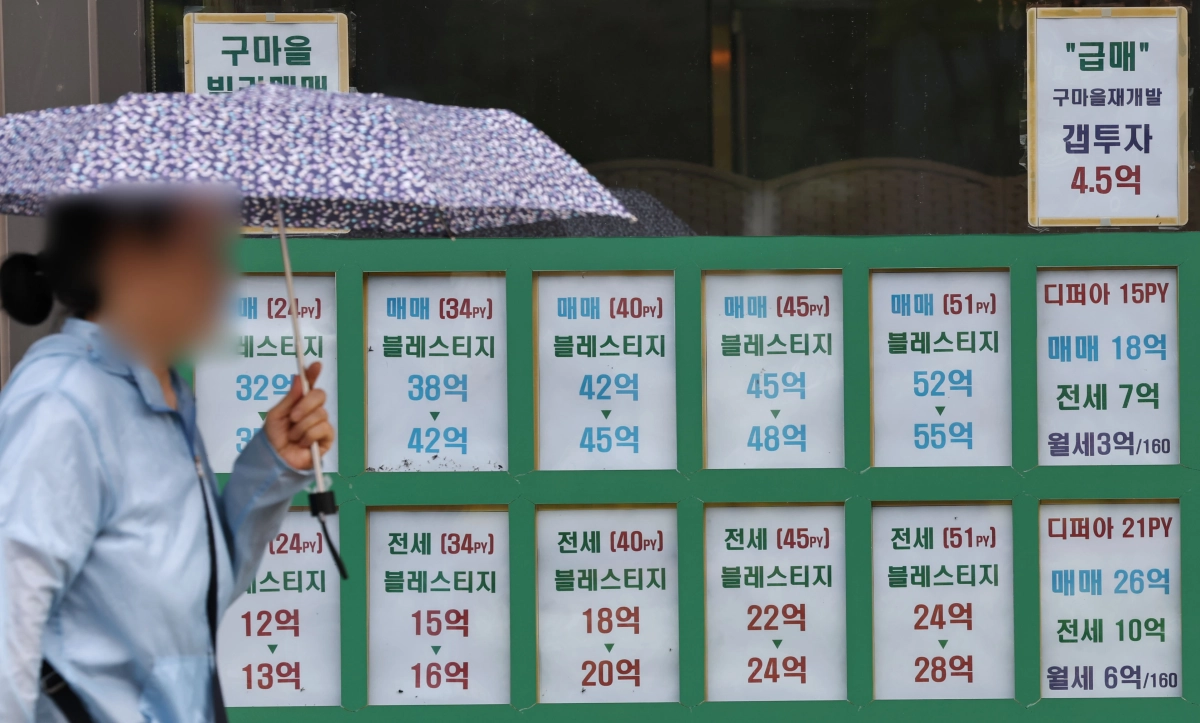 한 시민이 지난달 31일 서울 강남구의 한 부동산중개업소를 지나고 있다. 연합뉴스