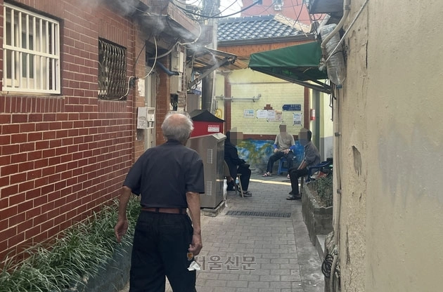 전국 대부분 지역에 폭염 경보가 내려진 2일 서울 창신동 쪽방촌 골목 초입에서 주민들이 냉각 안개 아래 그늘에 의자를 옮겨 놓고 무더위를 견디고 있다. 박다운 기자