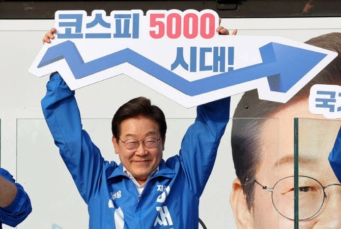 29일 당시 이재명 더불어민주당 대선 후보가 서울 서초구 서울고속버스터미널광장에서 열린 유세에서 ‘코스피 5000 시대’ 팻말을 들고 경제회복 퍼포먼스를 하고 있다. 2025.5.29 뉴시스