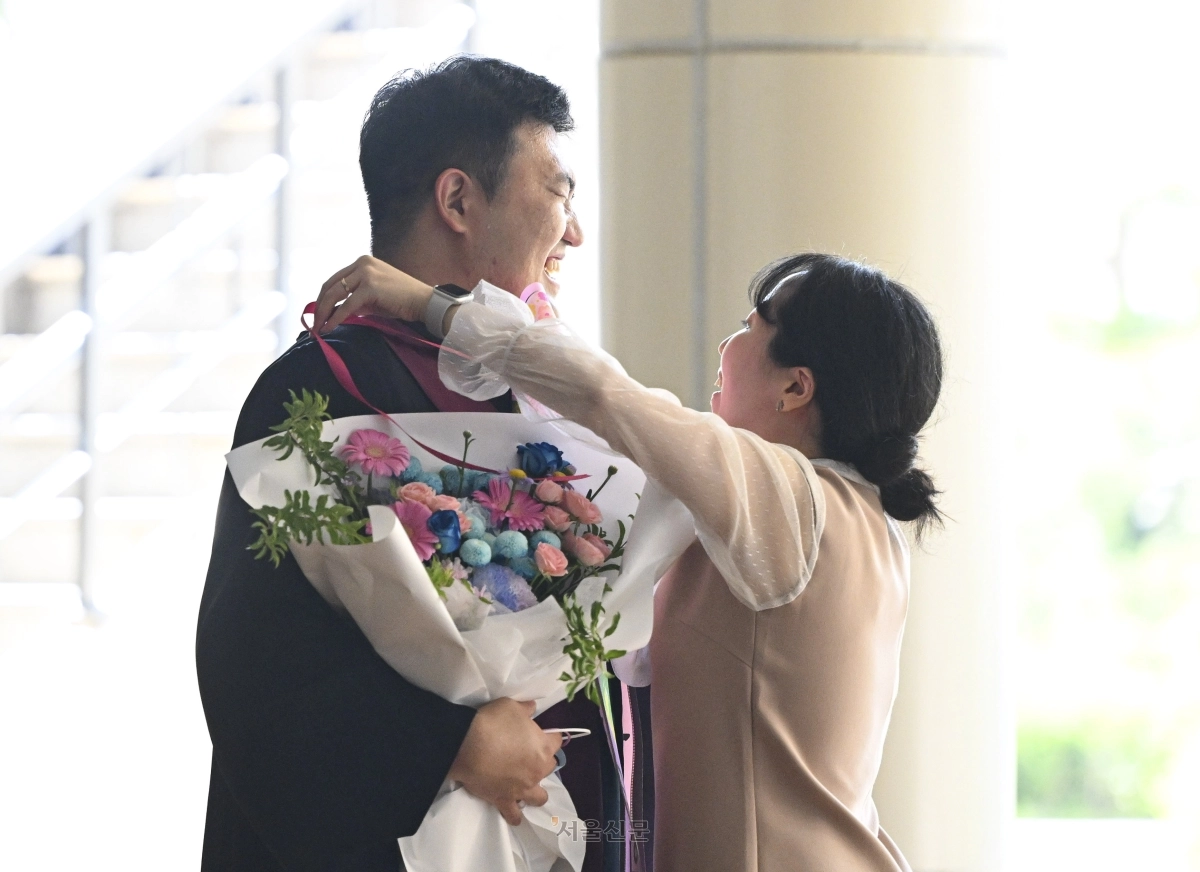 한 신임 검사의 아내가 3일 경기 과천시 정부과천청사 대강당에서 열린 신임 검사 임관식을 마치고 남편에게 기념 리본을 달아주고 있다. 2026.8.3 이지훈 기자