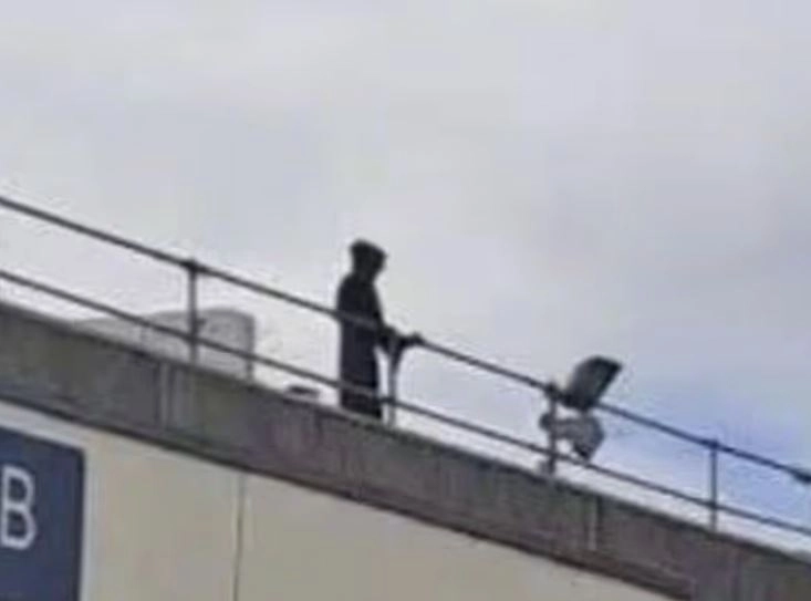 레온 길레스피(26)가 검은색 후드 의상을 입고 영국 웨일스 덴비셔주 이스비티 글란 클루이드 병원 지붕에 올라가 방문객들을 노려보고 있다. 데일리메일 캡처