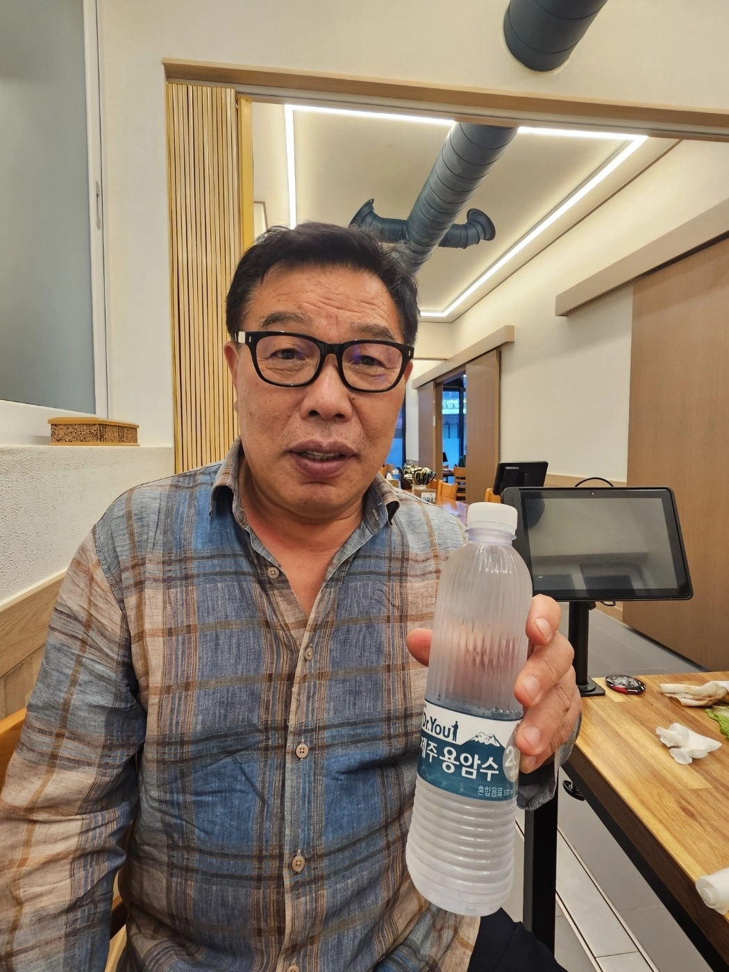 고영우 순천시소상공인연합회장이 하루 200개씩 무료로 배부하고 있는 ‘제주 용암수’를 들고 웃음을 짓고 있다.