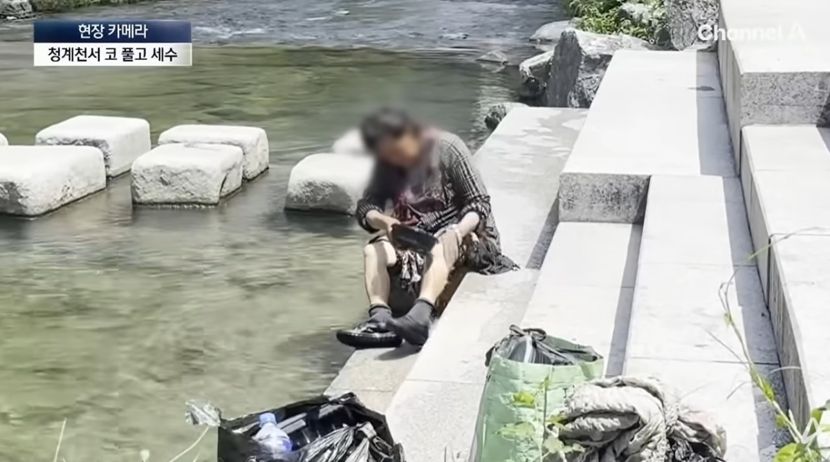 서울 청계천을 찾은 한 시민이 청계천 물로 몸을 씻는 모습. 자료 : 채널A