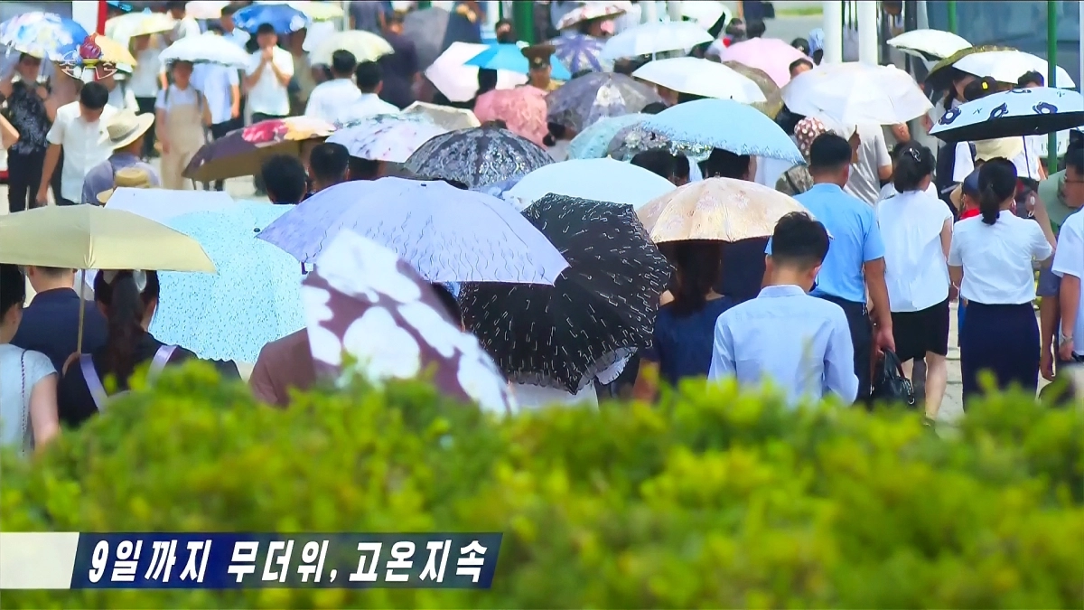 북한이 오는 9일까지 무더위가, 8일까지는 평양시와 평안북도·자강도 등지에서 35∼40도의 고온 현상이 지속되겠다고 예보한 가운데 평양 시민들이 양산을 쓴 채 거리를 걷고 있다. 2026.8.6 조선중앙TV 화면 연합뉴스