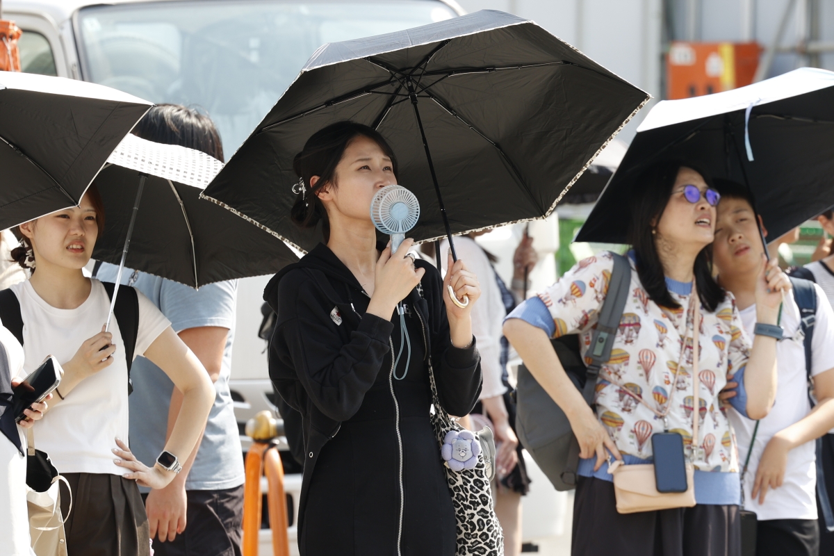 2026년 7월 22일 일본 도쿄에서 보행자들이 높은 기온 속에서 햇볕을 가리기 위해 양산을 사용하고 있다. EPA 연합뉴스