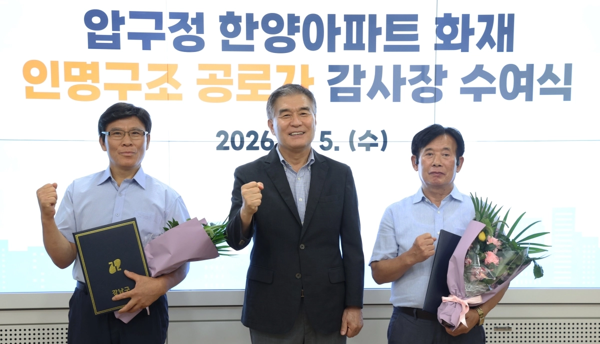 김현기(가운데) 강남구청장이 5일 한양아파트 화재 당시 적극적으로 주민 대피를 도왔던 김종각(왼쪽), 박한철 경비원에게 감사장을 수여한 뒤 기념촬영을 하고 있다. 강남구 제공