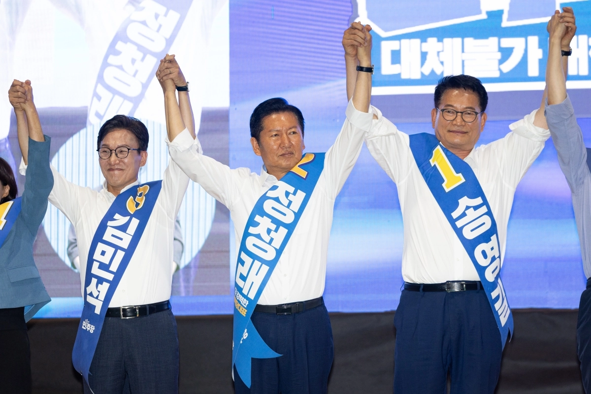 더불어민주당 8·17전당대회 당대표 선거에 출마한 김민석(왼쪽부터)·정청래·송영길 후보가 9일 강원 횡성군 횡성국민체육센터에서 열린 강원 순회경선 합동연설회에 앞서 잡은 손을 올려 인사하고 있다. 횡성 뉴스1