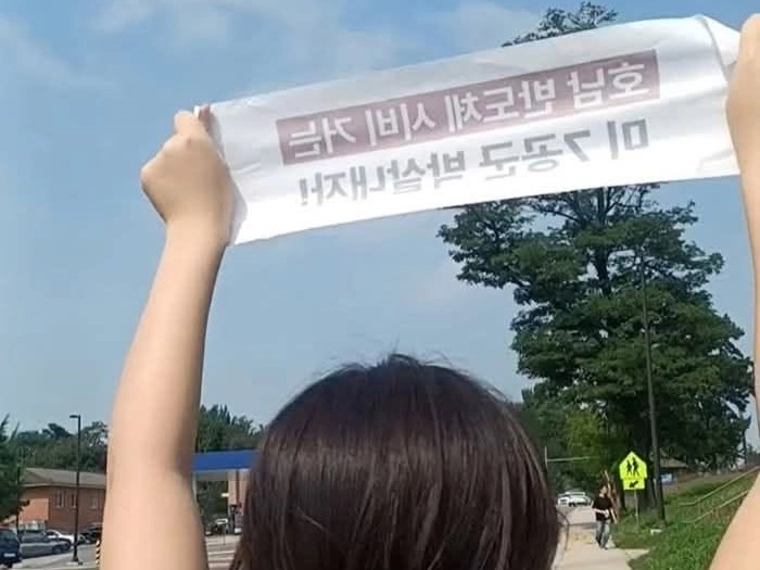 지난 4일 오전 경기 평택시 주한미군 오산공군기지(K55)에 무단침입한 혐의를 받는 한국대학생진보연합(대진연) 소속 학생이 ‘호남 반도체 시비 거는 미 7공군 박살내자’라는 문구를 들고 있다. 황선 함께만드는통일세상 평화이음 이사 페이스북 캡처