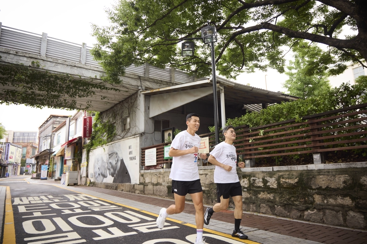 SK텔레콤은 광복 81주년을 기념해 국가보훈부, 독립기념관과 ‘1만 8776명의 독립운동가 기억하길’ 캠페인을 진행한다고 10일 밝혔다. 사진은 정재헌(오른쪽) SK텔레콤 최고경영자(CEO)와 가수 션이 지난달 서울 종로구에 조성된 ‘독립을 이끈 여성들을 기억하길’ 코스를 함께 달리는 모습. SK텔레콤 제공