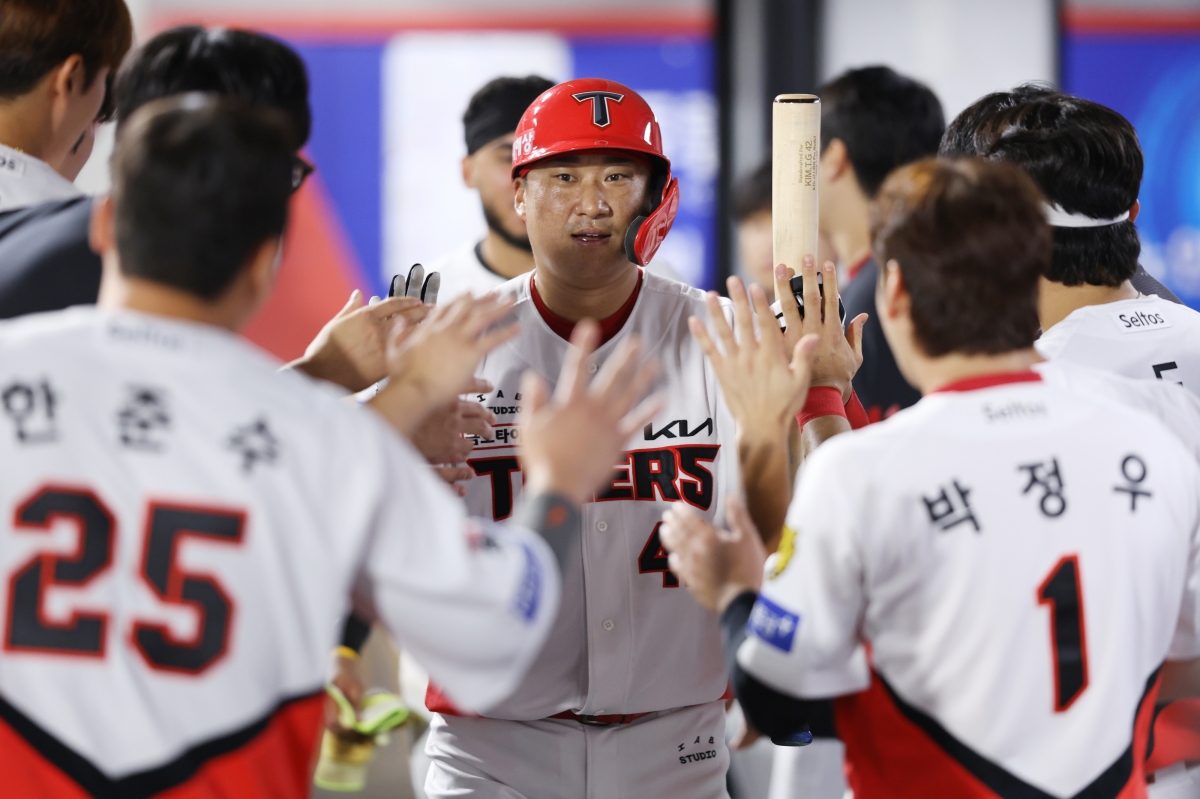 KIA 타이거즈 포수 김태군(가운데)이 11일 삼성 라이온즈와의 경기에서 희생 플라이로 3타점째를 거둔 뒤 동료들의 환영 속에 더그아웃으로 들어가고 있다. KIA 타이거즈 제공