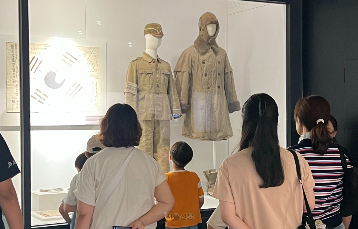 광복절을 이틀 앞둔 13일 서울 노원구 육군사관학교 내 육군박물관을 찾은 시민들이 한국광복군 예비대 군복을 관람하고 있다. 이 옷은 유일하게 현재까지 보존된 광복군 군복이다.