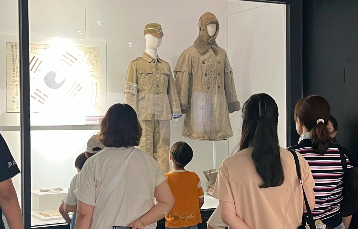 광복절을 이틀 앞둔 13일 서울 노원구 육군사관학교 내 육군박물관을 찾은 시민들이 한국광복군 예비대 군복을 관람하고 있다. 이 옷은 유일하게 현재까지 보존된 광복군 군복이다.