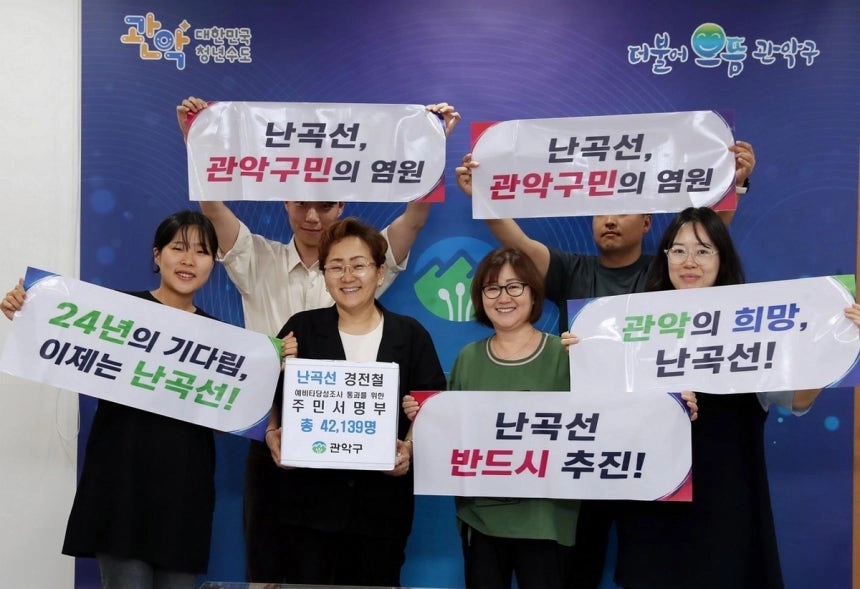 관악구 관계자들이 난곡선 경전철 예비타당성조사 통과를 요구하는 4만여명의 주민 서명부를 들고 사진을 찍고 있다.  관악구 제공