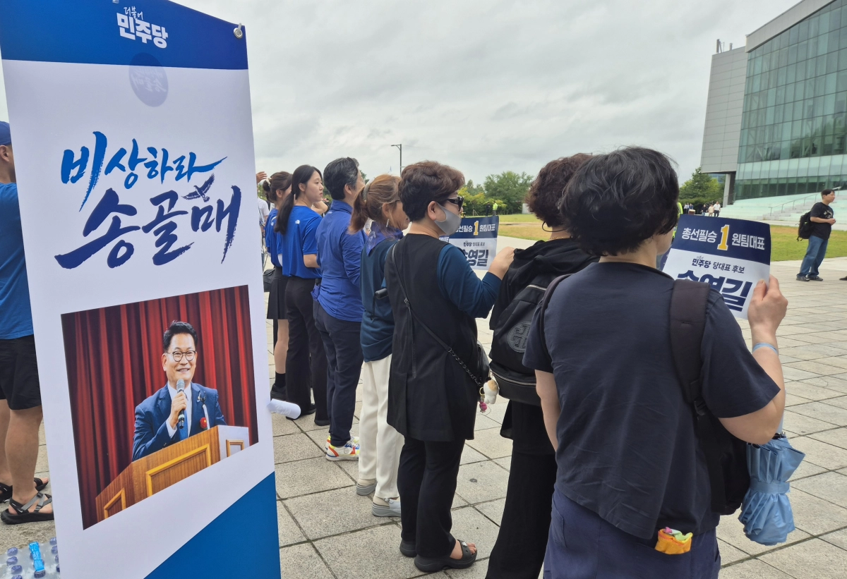 더불어민주당 전당대회 서울 순회경선이 열리는 16일 오후 경기 고양시 킨텍스 앞에서 송영길 당대표 후보를 지지하는 시민들이 송 후보를 기다리며 ‘총선필승 원팀대표’라고 적힌 손팻말을 들고 있다. 반영윤 기자