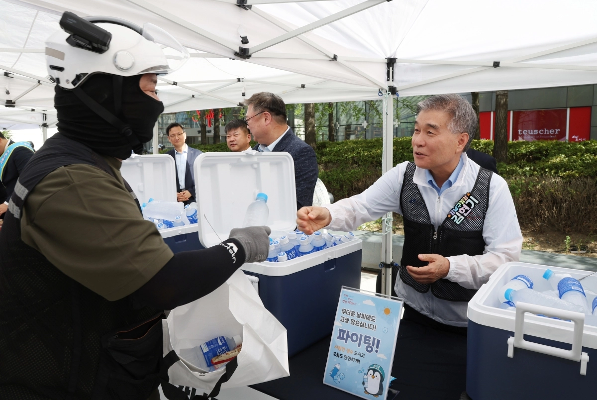 김현기(오른쪽) 강남구청장이 12일 삼성동 무역센터 앞에서 진행된 ‘폭염대비 안전지원 캠페인’에서 이동노동자에게 얼음 생수를 전달하고 있다.  강남구 제공