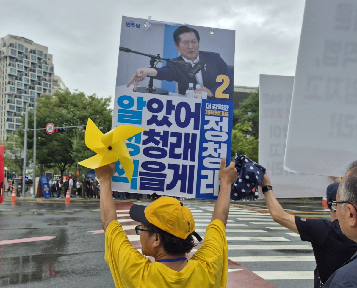 정청래 더불어민주당 대표 후보를 지지하는 당원이 노란색 옷과 모자를 쓰고 노란 바람개비를 든 채 ‘알았어 정청래(기호 2번) 찍을게’(알정찍)라고 적힌 손팻말을 흔들고 있다. 대전 반영윤 기자