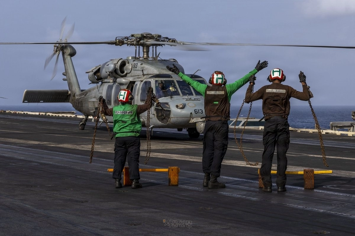 미 해군 수병들이 중동에 전개된 핵추진 항공모함 USS 에이브러햄 링컨 비행갑판에서 MH-60S 시호크 헬기의 이동을 유도하고 있다.  CENTCOM X 캡처