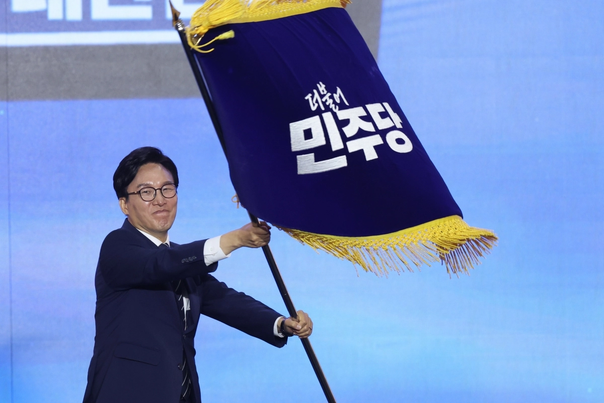 김민석 신임 더불어민주당 대표가 17일 오후 대전 유성구 DCC대전컨벤션센터에서 열린 ‘더불어민주당 제3차 정기전국당원대회’에서 당기를 흔들고 있다.  뉴스1