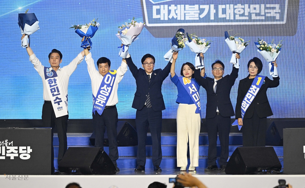김민석 신임 대표 등 더불어민주당 새 지도부가 17일 대전 유성구 대전컨벤션센터에서 열린 8·17 전당대회에서 손을 잡고 인사하고 있다. 왼쪽부터 한민수·이성윤 최고위원, 김 대표, 서미화·박선원·최민희 최고위원. 대전 이지훈 기자