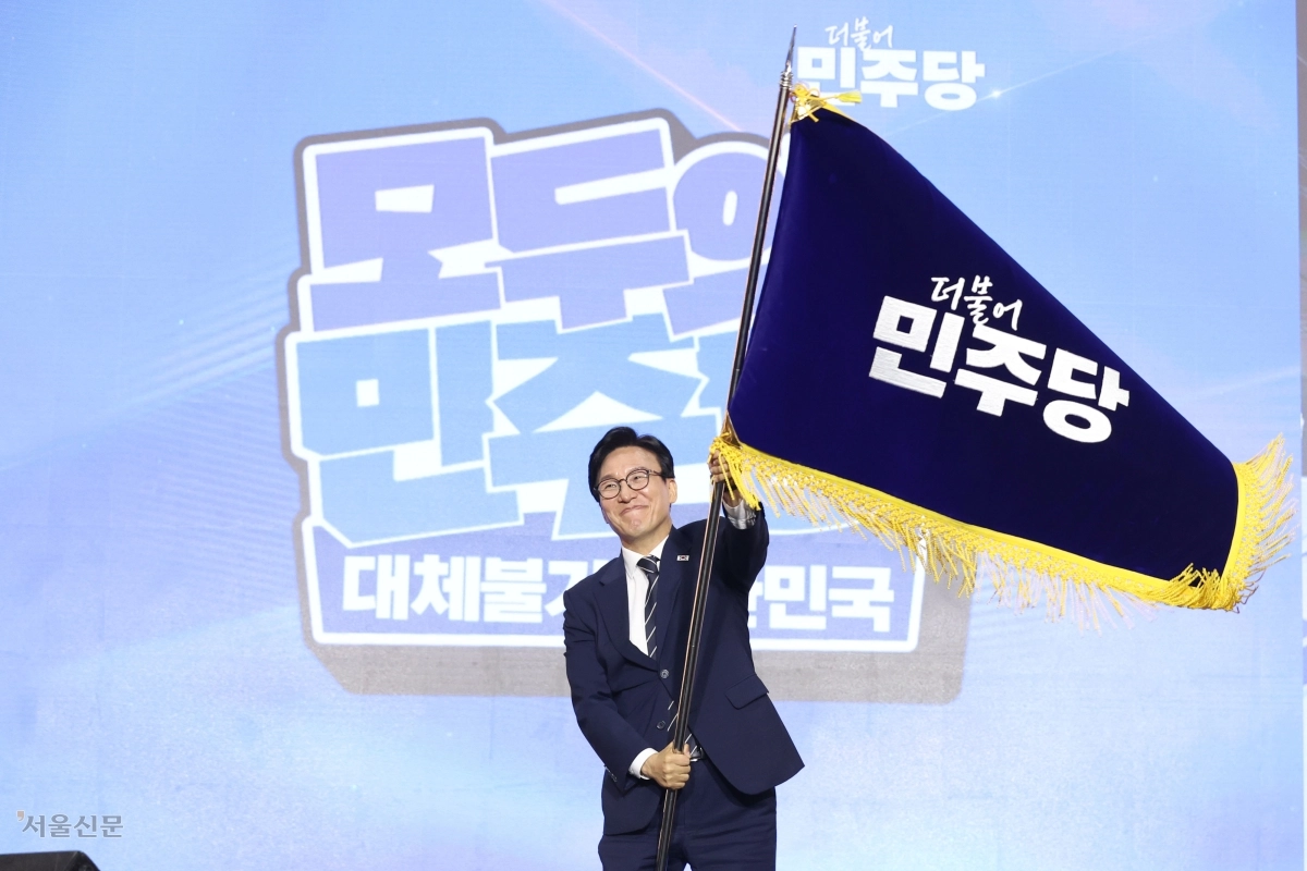 김민석 더불어민주당 신임 대표가 17일 대전 유성구 대전컨벤션센터에서 열린 8·17 전당대회에서 선호투표 적용 끝에 승리한 뒤 당기를 흔들고 있다. 김 대표는 “당청 관계는 국정의 중심인 대통령과 정부를 지원하는 전면 협력의 창조적 수평 관계가 될 것”이라고 강조했다. 대전 이지훈 기자
