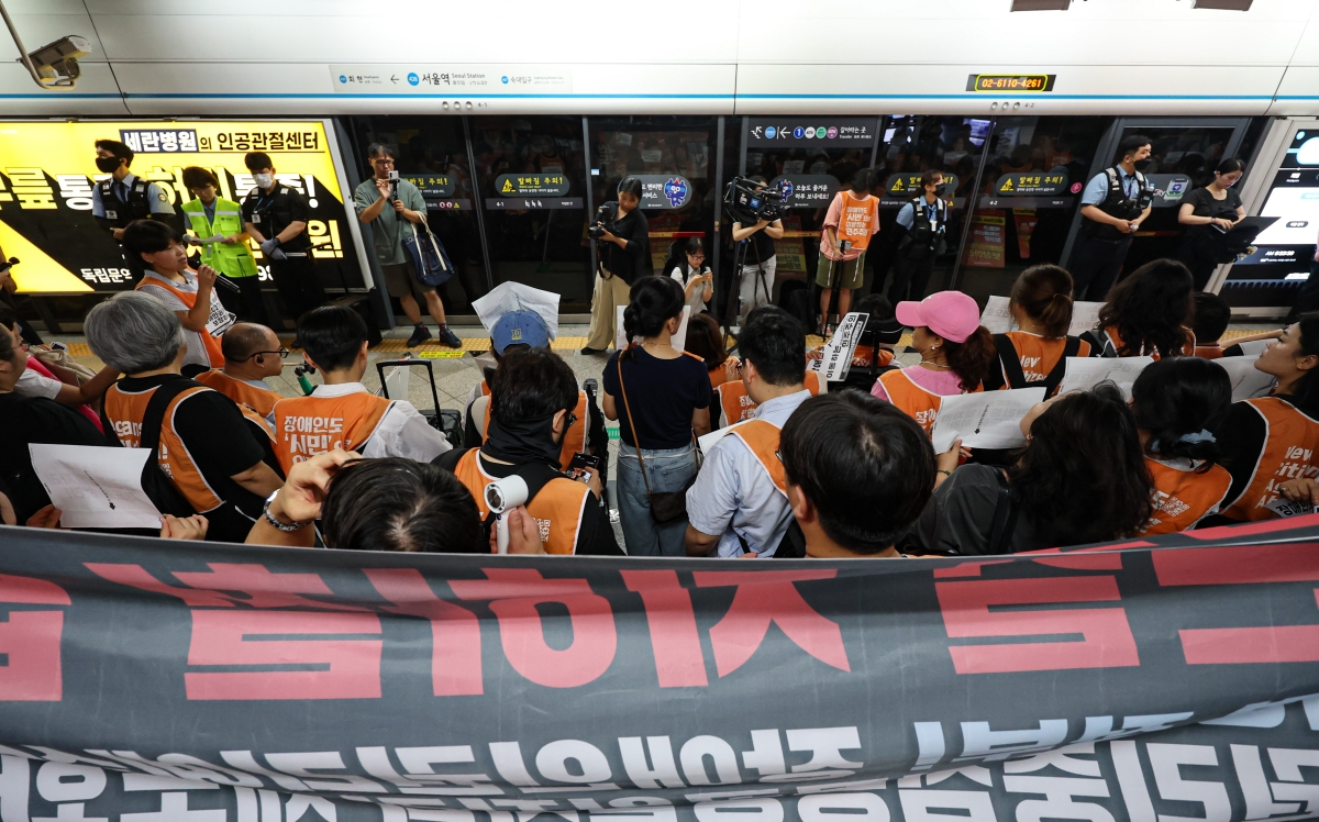 전국장애인차별철폐연대(전장연) 활동가들이 18일 오전 서울 지하철 4호선 서울역에서 ‘72차 출근길 지하철 탑니다’ 시위를 하고 있다. 2026.8.18 뉴스1