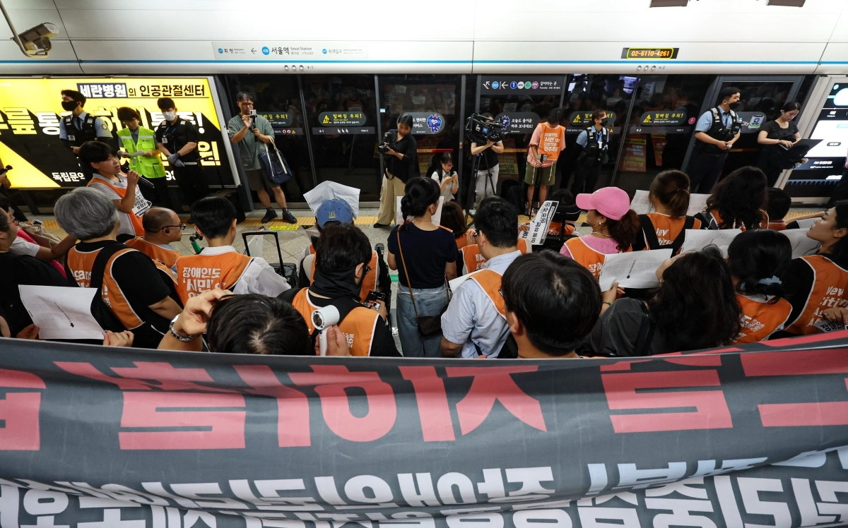 전국장애인차별철폐연대(전장연) 활동가들이 18일 오전 서울 지하철 4호선 서울역에서 ‘72차 출근길 지하철 탑니다’ 시위를 하고 있다. 2026.8.18 뉴스1
